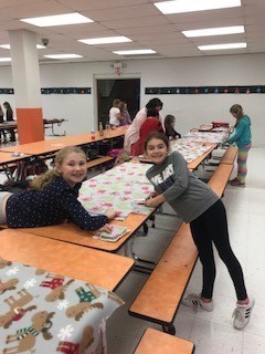 people around a table with a cloth on it